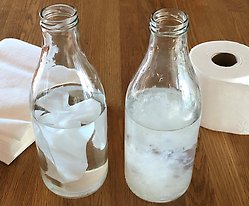 Flaskor som visar hur tvättlappar respektive toalettpapper löser upp sig i vatten.